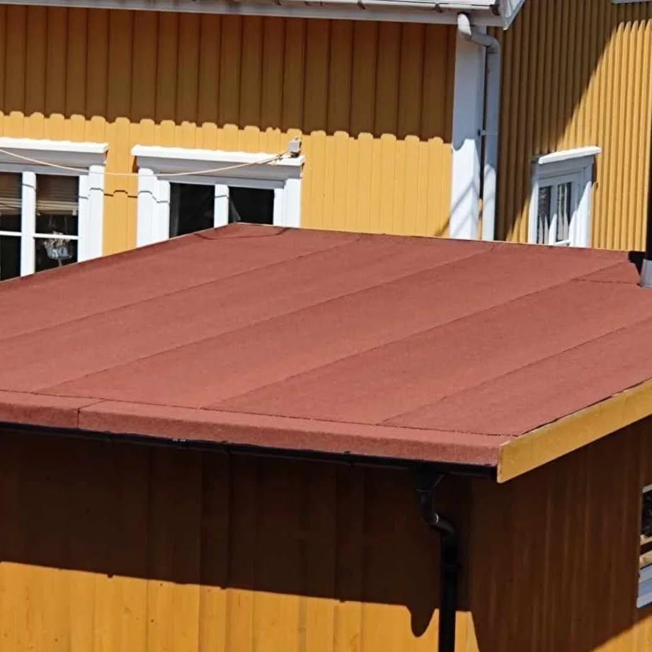 Lite tak med rød takshingel over en inngang